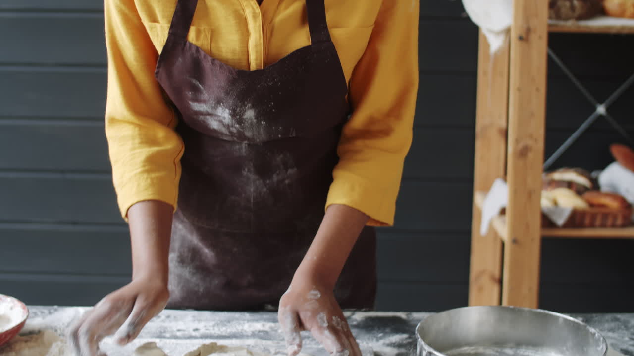 Black Female Baker Kneading Dough on Kitchen Table