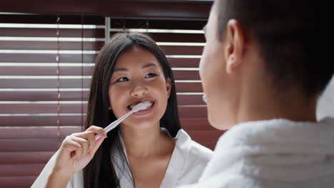 pareja cepillándose los dientes en el baño