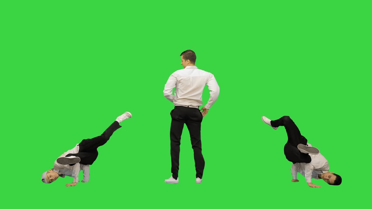 녹색 스크린, 크로마 키에서 카메라를 보고 동기화 된 브레이크 댄스를하는 세 명의 남자
