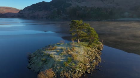 Pequeña-Isla-En-Un-Lago-Tranquilo-Con-Niebla-Moviéndose-A-Través-Del-Agua-Y-Orbitando-Revelando-Un-Lago-Más-Amplio