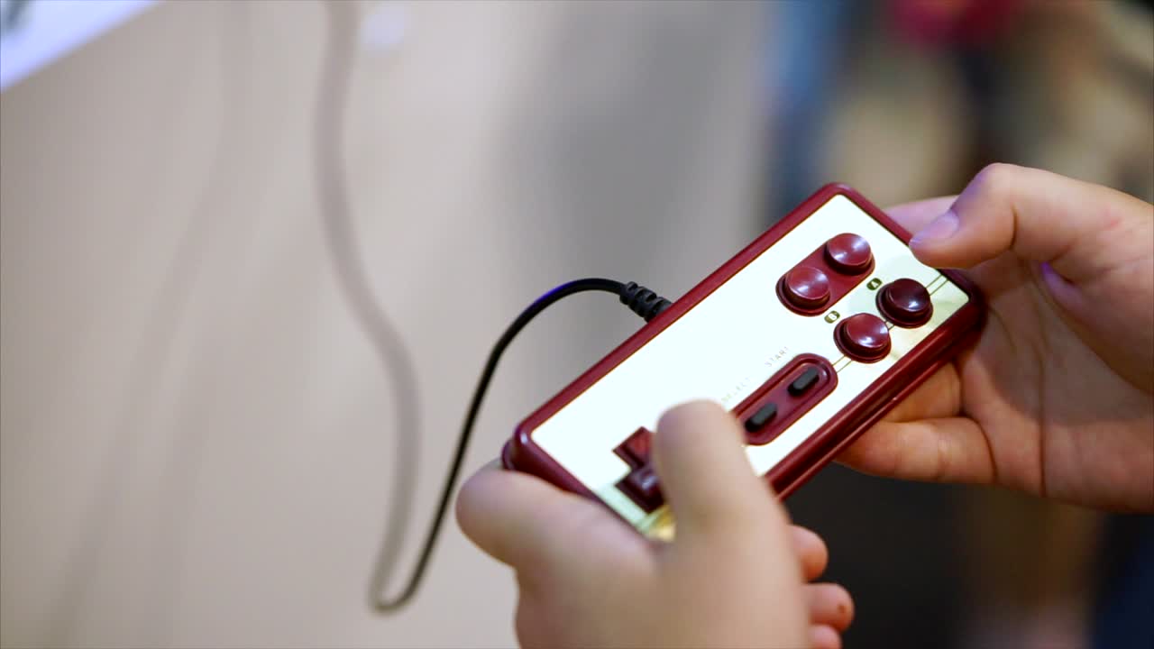 Hands holding a vintage video game controller