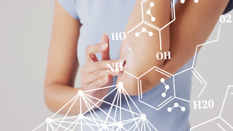 animación de estructuras químicas sobre una mujer biracial poniendo crema en su brazo