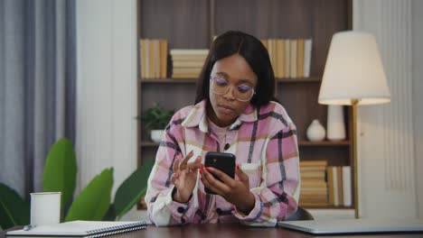 mujer usando teléfono inteligente en la oficina del hogar