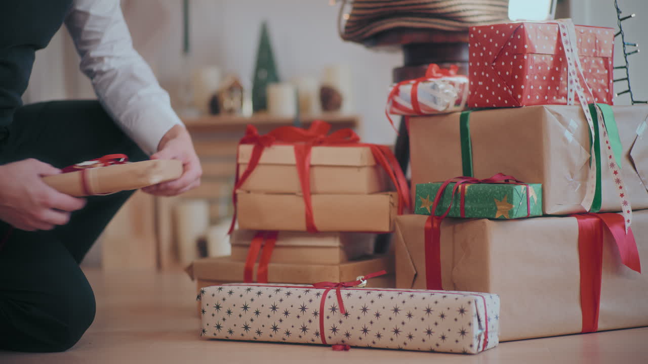 집 의 바닥 에 여러 가지 크리스마스 선물 을 배열 하는 사람