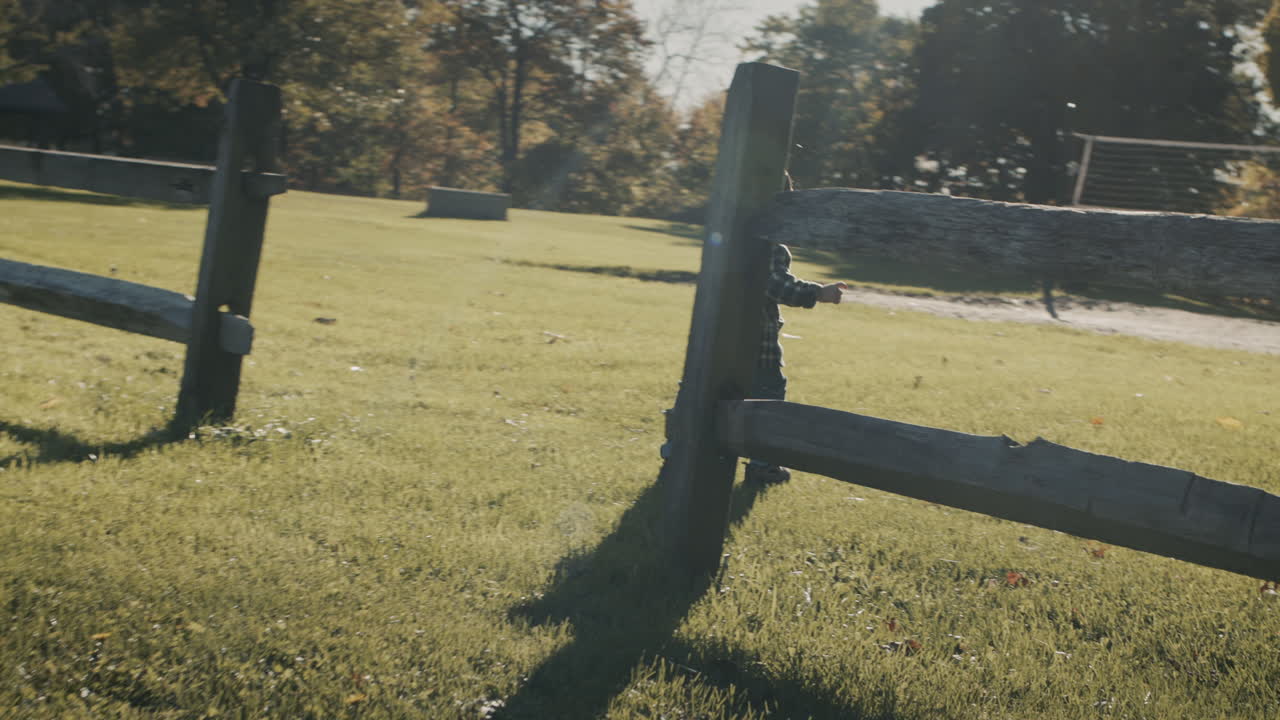 아이는 부모 농장의 울타리를 돌아다니고 있습니다. 건강하고 활동적인 아기