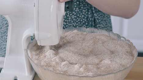 girl uses home flour grinder to make healthy food at table