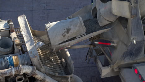 slow-motion-close-up eines betonmischer-lkw, der frische zementmischung auf einer baustelle in mexiko in eine boompumpe gießt