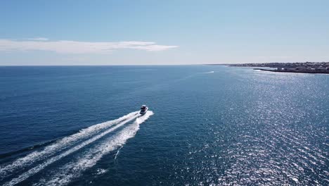 drone follow shot of fast white yacht and shimmering sea australia