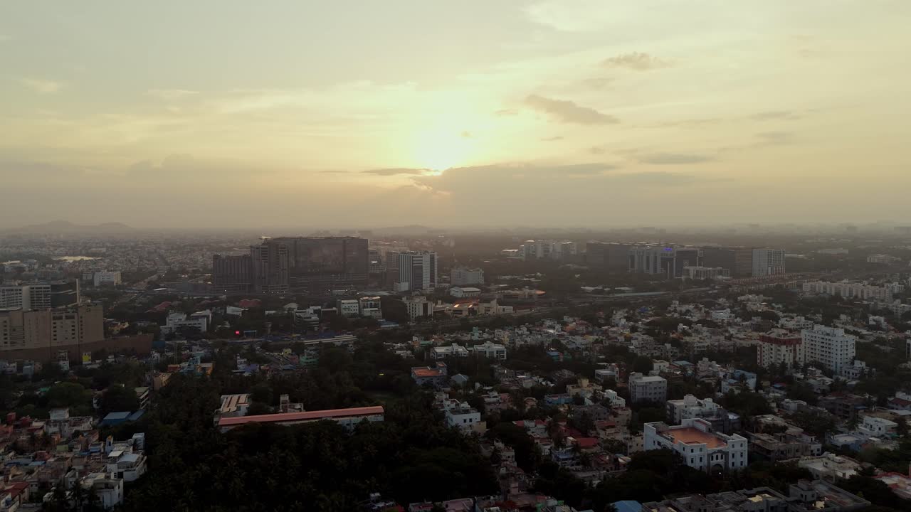Moving drone shot of cityscape during sunset over Indian city.