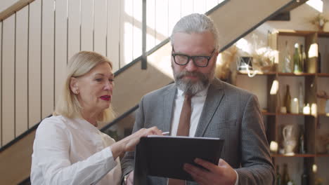 colegas de alto nivel discutiendo documentos de negocios en un restaurante