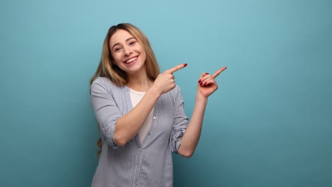 woman pointing to side copy space, gesturing attention to empty wall for commercial text.