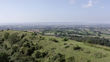 aerial - couple walk their dog on a hill, uley, cotswolds, england, reverse shot