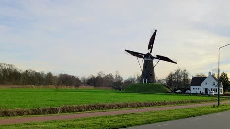 a moving dutch windmill in the countryside with sunset