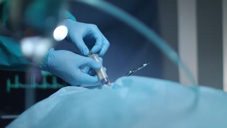 surgeon hands with syringe suction blood. blood syringe. surgeon operating