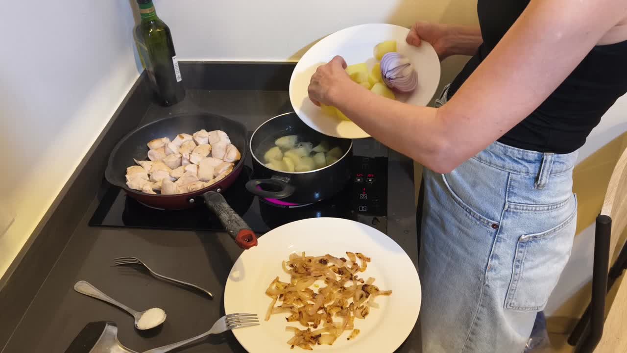 Cooking chicken, potatoes and onions in the kitchen
