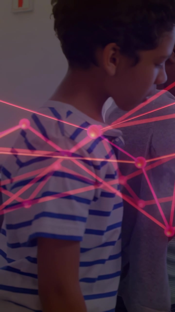 Vertical video: Striped kid watching exhibit, camera panning left, pink network wrapping children