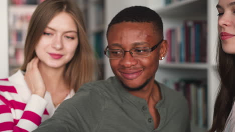 a group of friends taking a selfie in a library