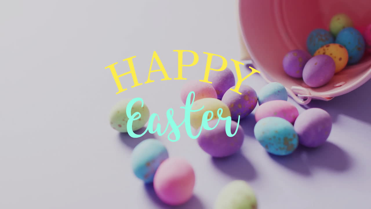 Animazione del testo "Buona Pasqua" su uova di Pasqua colorate e un secchiello rosa su sfondo viola.