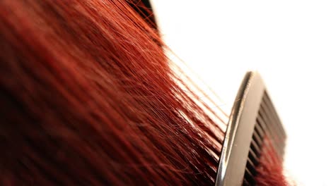 detalle de peinar el pelo rojo rizado, tiro macro