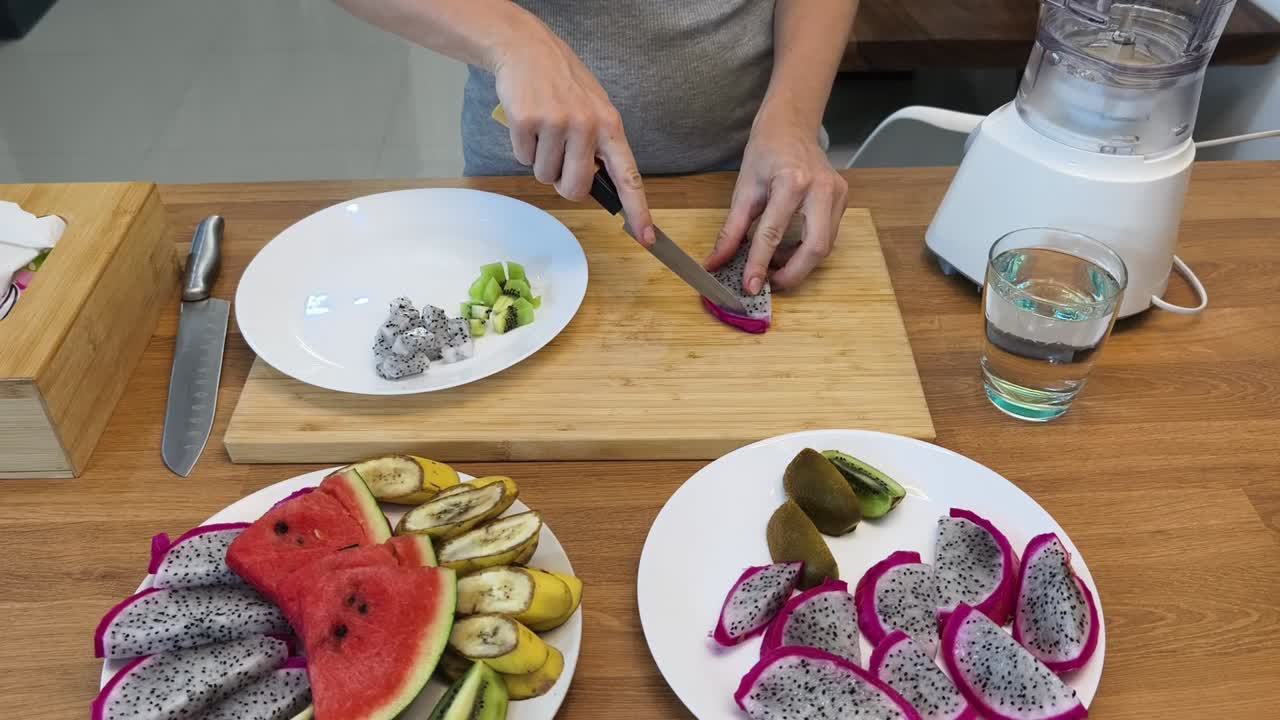preparando una ensalada de frutas con fruta del dragón, kiwi, sandía y plátano