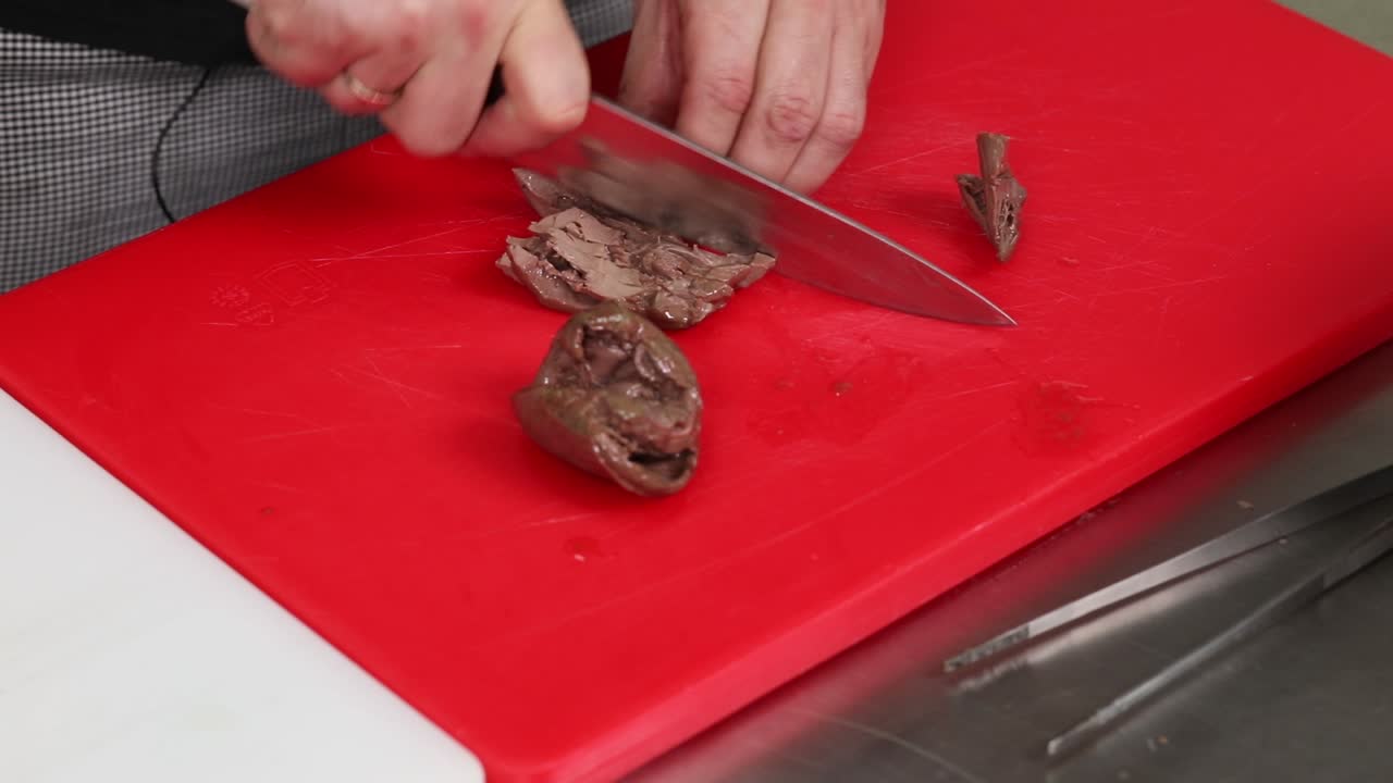 셰프가 원시 간을 잘라내고 있습니다.