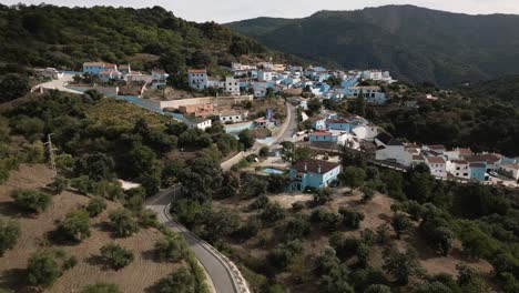 Smurf-village-of-Juzcar-in-Spain,-aerial-descend-view