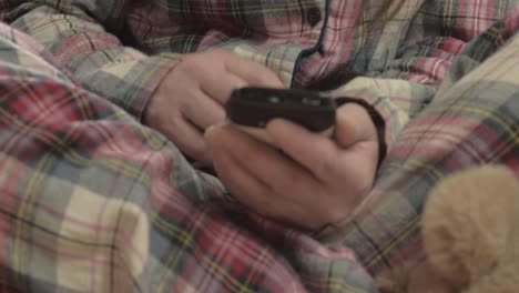 woman in pajamas using mobile phone close up