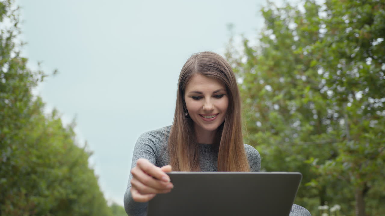 mujer trabajando en una computadora portátil en un parque