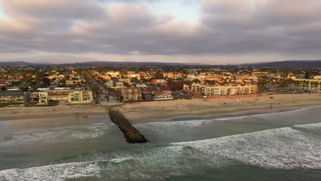 espigón de roca con olas entrando en la orilla arenosa de la playa imperial en california, ee.uu.