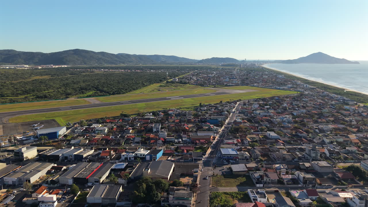 Vista panoramica dell'Aeroporto Internazionale di Navegantes con un quartiere residenziale che si estende verso la costa, Navegantes, Santa Catarina, Brasile