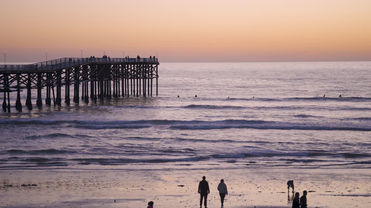 pacific beach california pier puesta de sol con olas rompiendo en la playa - cámara lenta del muelle en hora azul