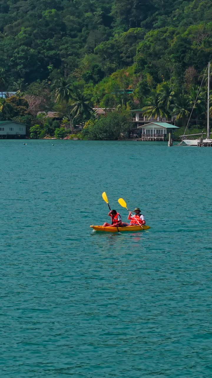 Persone che vanno in kayak in un oceano tropicale