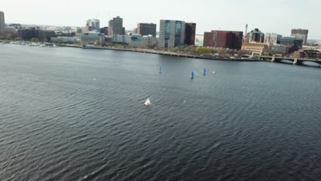 aerial view of sailboats in charles river with boston cityscape from cambridge, massachusetts - drone shot - out of focus