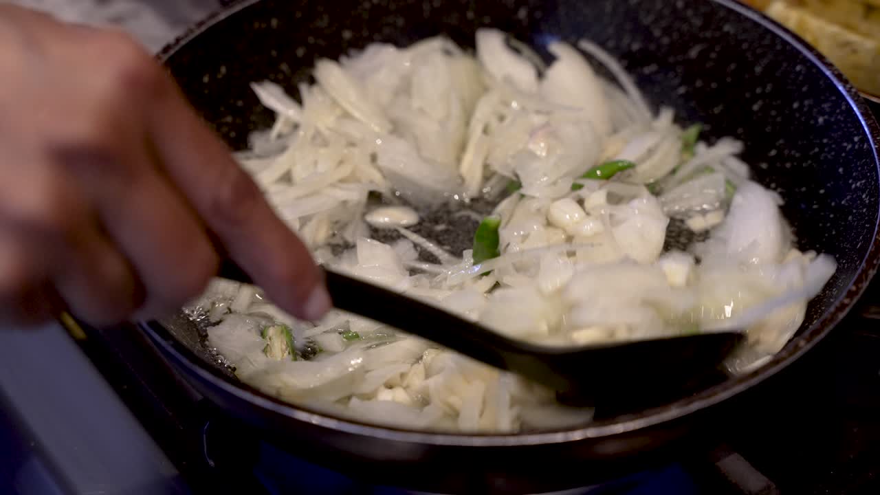 끓는 동안 휘젓는 신선한 자른 흰 양파