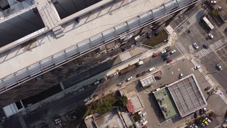 Vista-Aérea-De-Arriba-Hacia-Abajo-Que-Muestra-Un-Grupo-De-Limpiadores-De-Ventanas-Industriales-Limpiando-Un-Edificio-De-Rascacielos