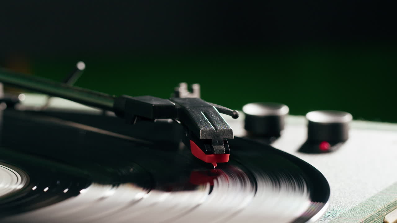 Una mano posiziona la puntina su un disco in vinile in rotazione su un giradischi
