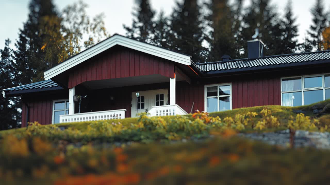 Landsted med steinflistak i høstlandskapet i Nord-Norge. En hvit benk står på verandaen