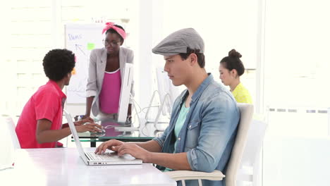 Creative-business-team-having-a-meeting-with-man-using-laptop