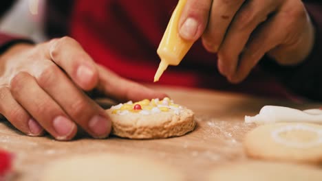 primer plano de un hombre decorando galletas para navidad