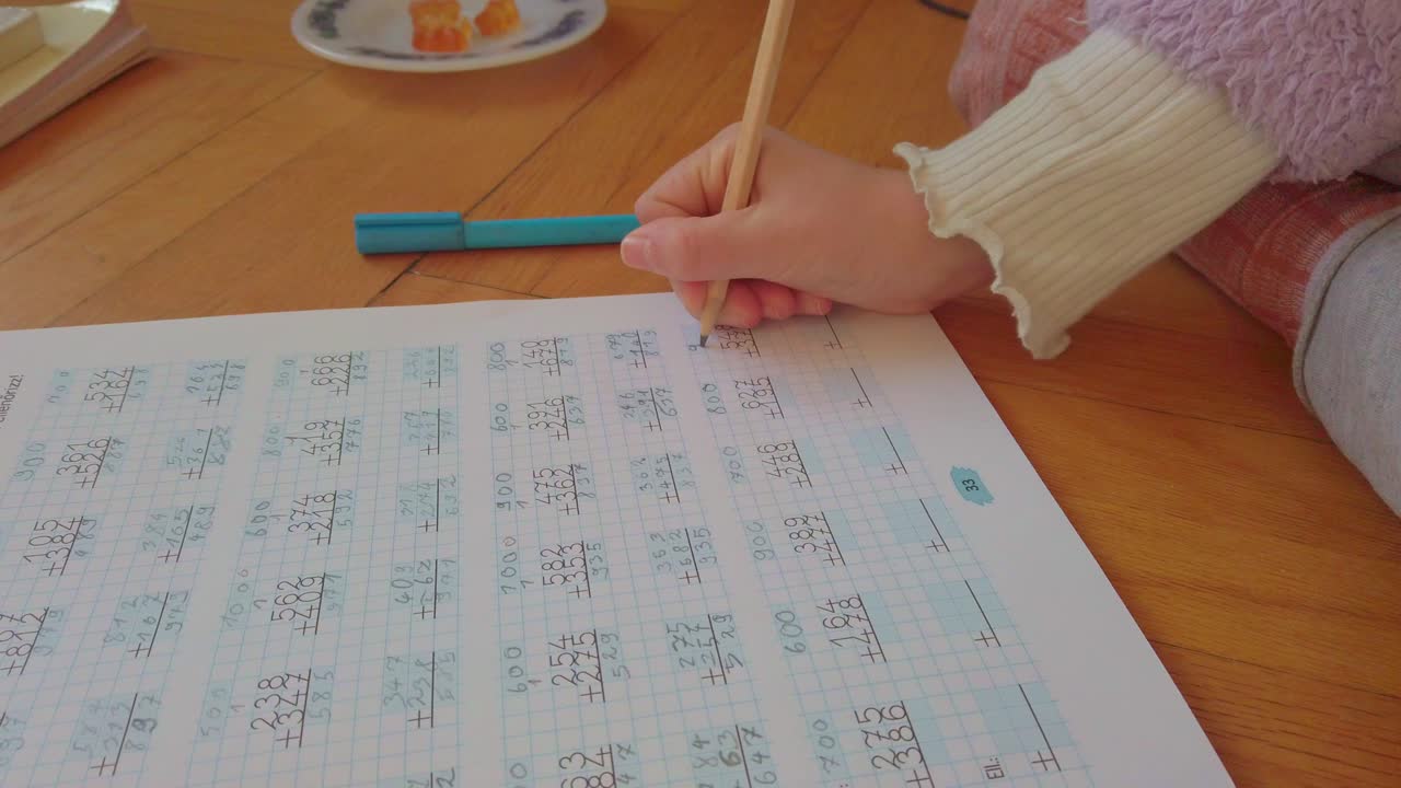 A focused young student diligently solves complex math in a notebook. This high-quality footage captures academic excellence, disciplined study habits, and the essence of early childhood education