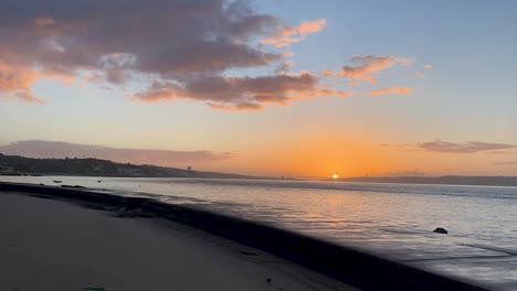 Toma-Panorámica-Amateur-De-La-Puesta-De-Sol,-La-Playa,-El-Océano-Y-El-Rompeolas-En-Cascais-Portugal