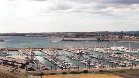 city of torrevieja and focusing to massive modern yacht pier, aerial drone view