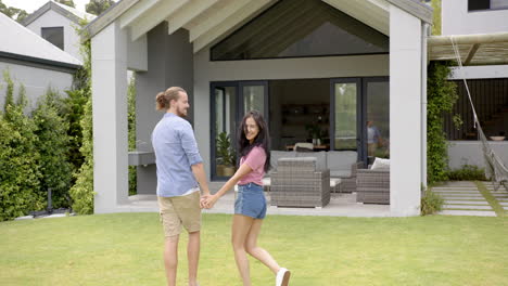 A-young-biracial-couple-enjoys-a-moment-in-their-backyard,-copy-space