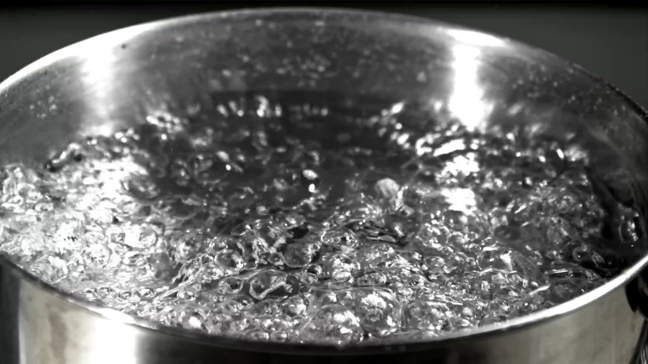 Acqua limpida che bolle rapidamente in una pentola d'argento