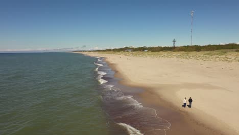 two women are walking along the beach