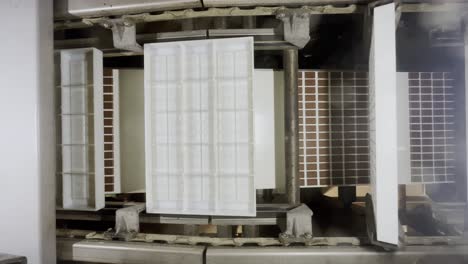 los moldes de plástico blancos se giraron en una fábrica en una línea de ensamblaje que produce pequeñas tiendas de chocolate en una fábrica