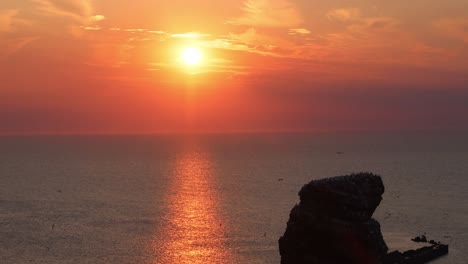 puesta de sol en los acantilados rojos de heligoland, alemania, europa