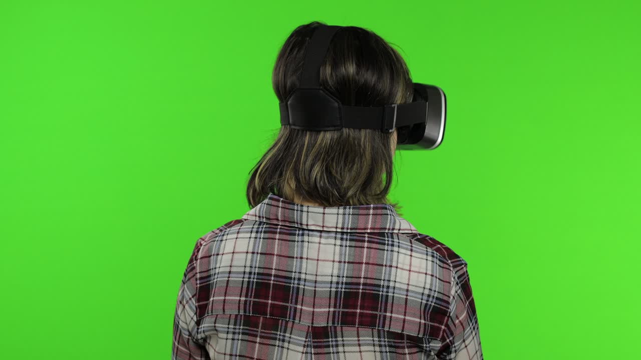 Giovane ragazza che usa un visore VR per giocare a un gioco di simulazione. Donna che guarda un video 3D di realtà virtuale
