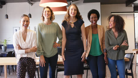 portrait of happy diverse businesswomen standing in office smiling to camera, in slow motion