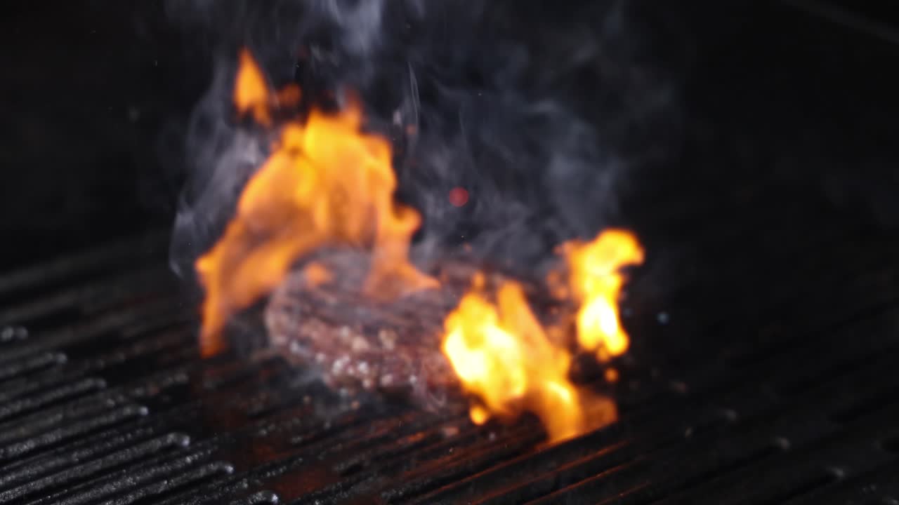 Hamburger che prende fuoco su una griglia
